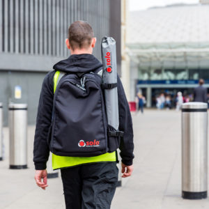 male technician walking outdoors with a smart kit