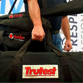 male holding trutest and solo equipment bags