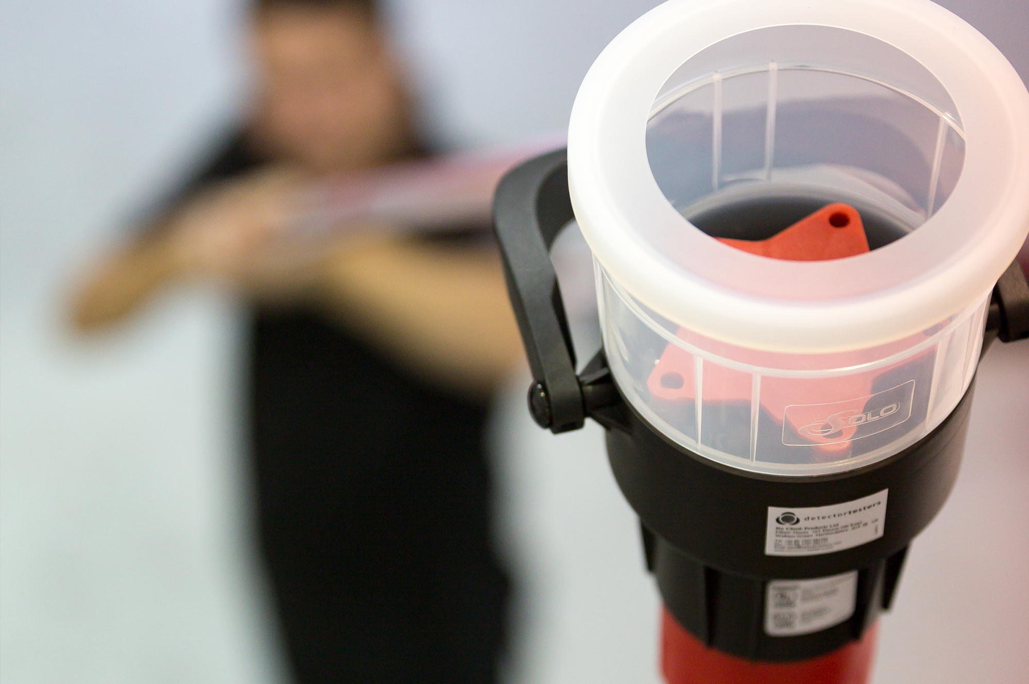 male holding a black and red solo 330 aerosol dispenser that has a transparent cup and is attached to a solo telescopic access pole