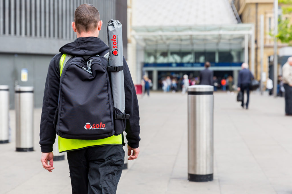 male technician walking outdoors with a smart kit
